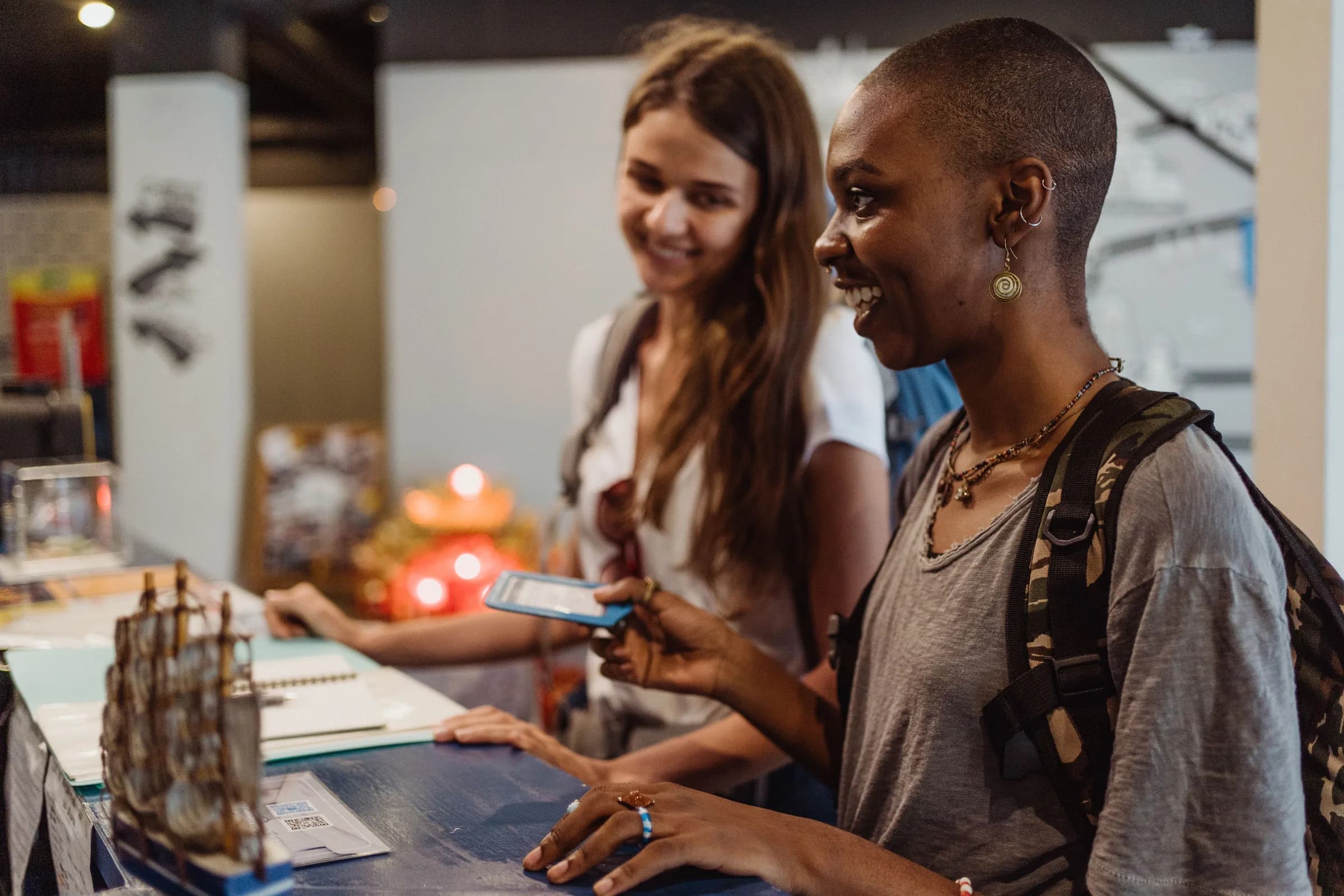 Two travellers smile as they check in at a bright hotel reception.